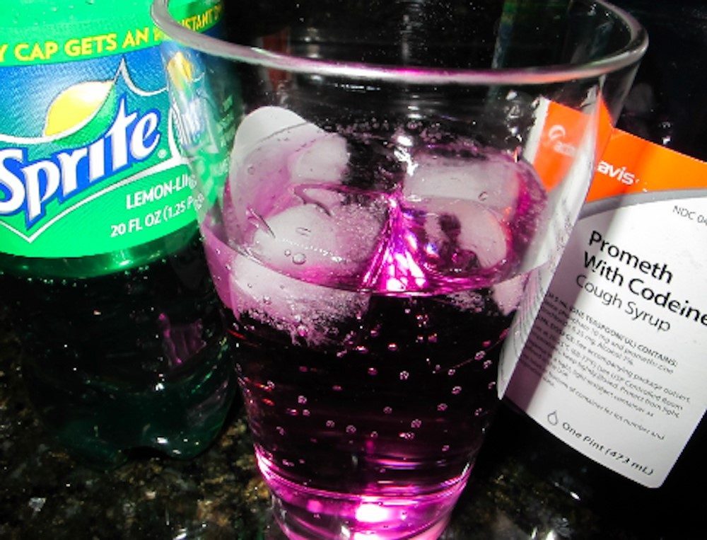 Alcohol and Codeine: Understanding the Risks Glass with purple drink, codeine syrup, and soda, highlighting alcohol and codeine risks.