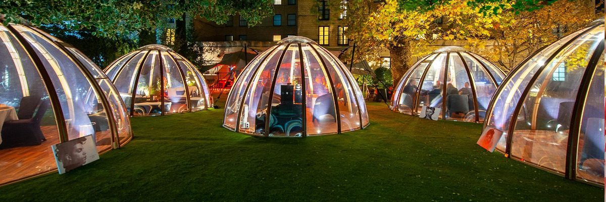 Unique Alcohol Free Activities in Outdoor Domes Lit-up glass domes offer cozy, alcohol free activities in a park setting.
