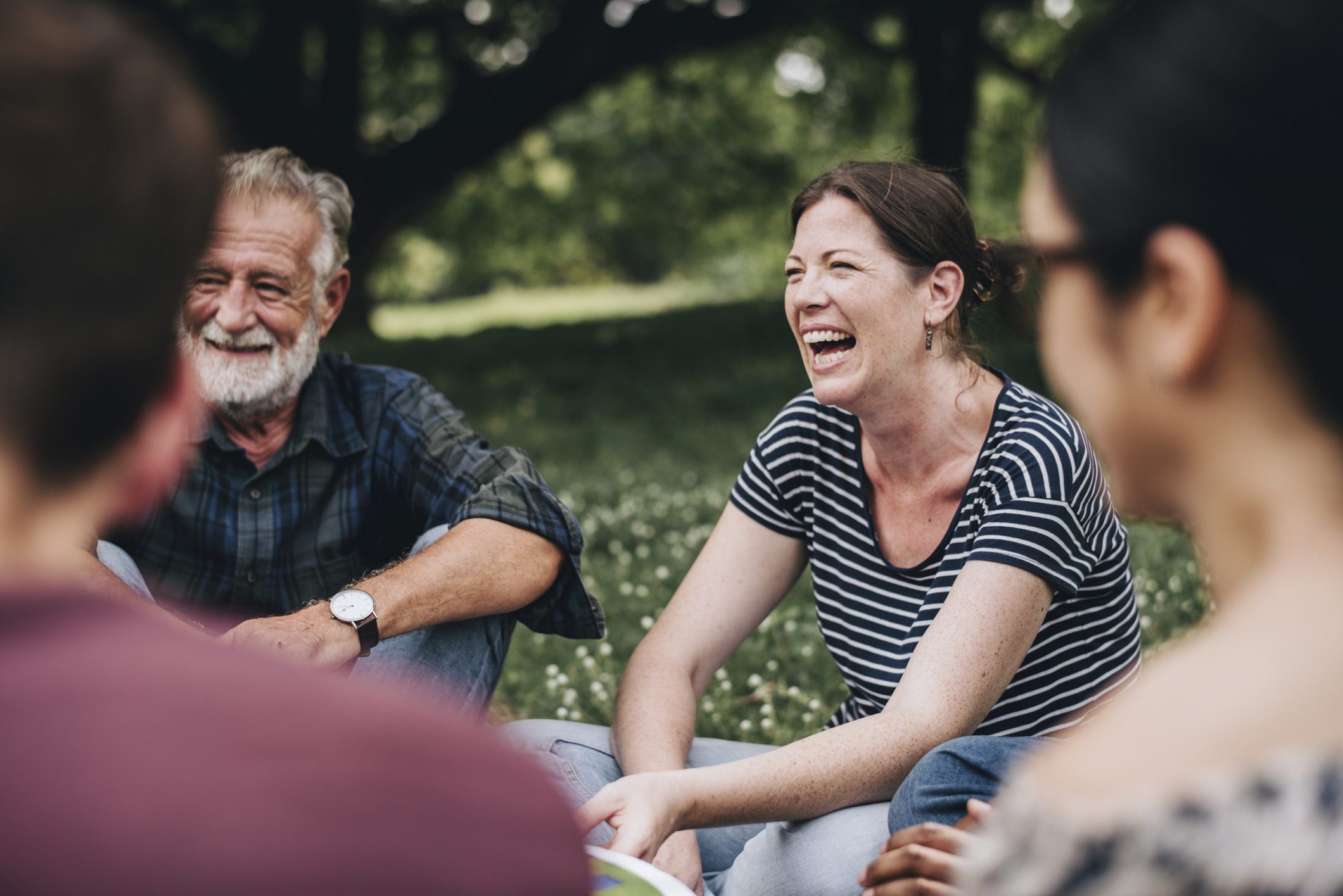 Smiling Group in Rehab Program Outdoors People enjoying a support group session in a park for alcohol recovery