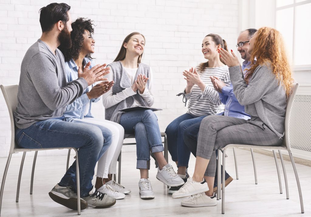 People in a circle clapping at alcohol rehab Cuddington support meeting