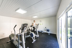 Alcohol Rehab Surrey: Modern Fitness Room Experience Individual exercising on bike in rehab gym, Alcohol Rehab Surrey facility