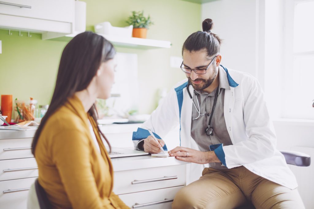 Doctor Consulting Patient for Alcohol Recovery Advice Doctor advising patient on alcohol recovery options in clinic