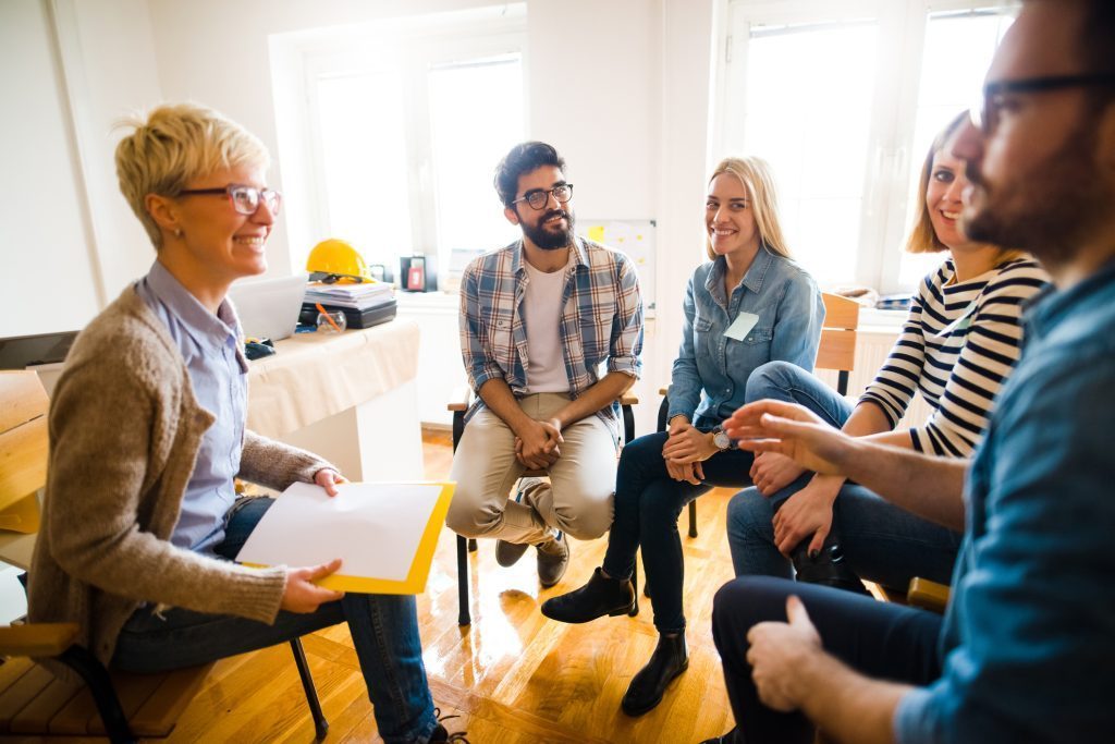 Supportive Group Therapy in Alcohol Recovery Programs Diverse group in therapy session discussing alcohol recovery