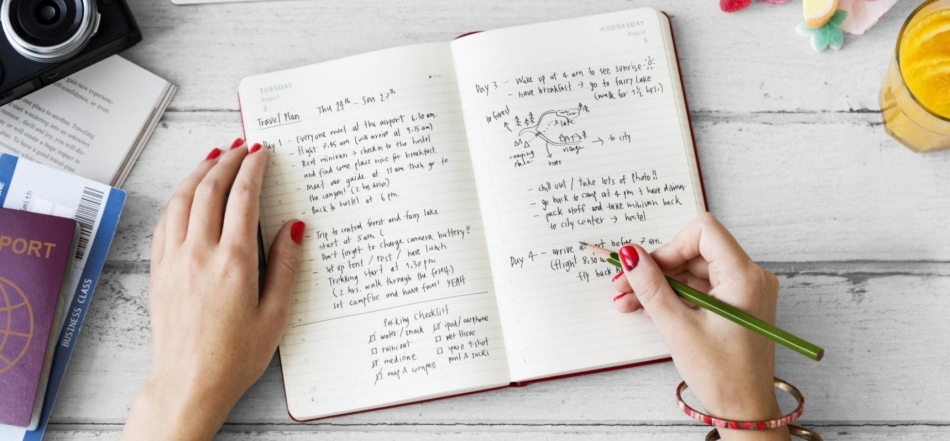 Planning and Journaling to Stop Drinking Alcohol A person writing a travel plan in a journal; tools to stop drinking alcohol.