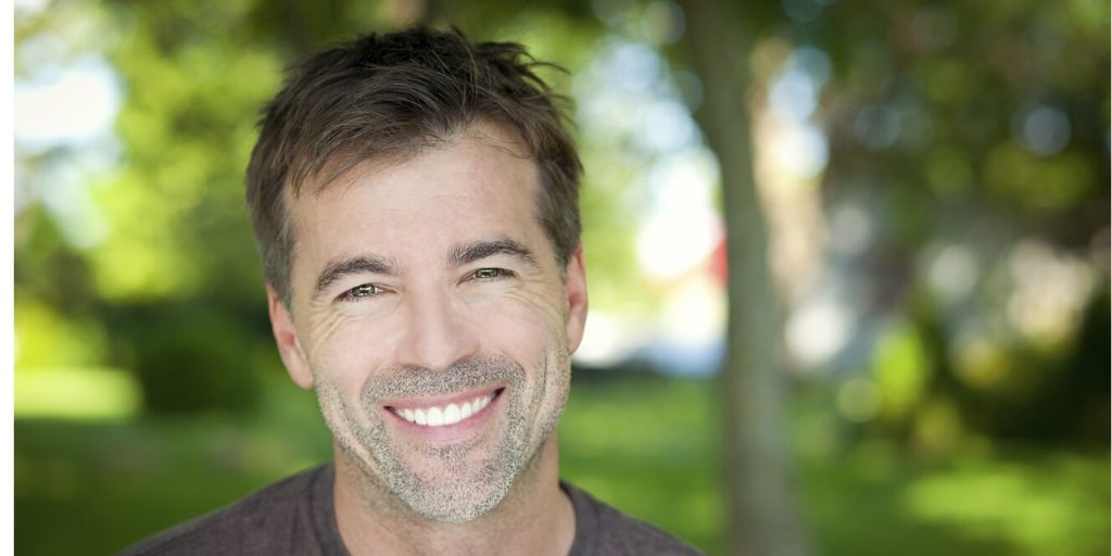 Rehab Reading: Personal Journeys to Recovery Smiling man in a park, symbolizing hope and success in Rehab Reading.