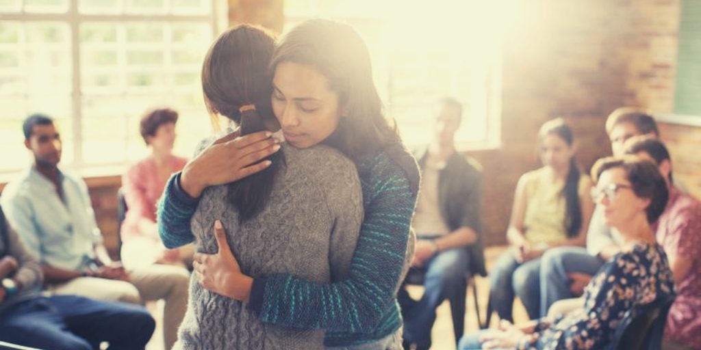 Rehab Torquay: Supportive Group Therapy for Alcohol Recovery Rehab Torquay session with people embracing in a supportive circle.