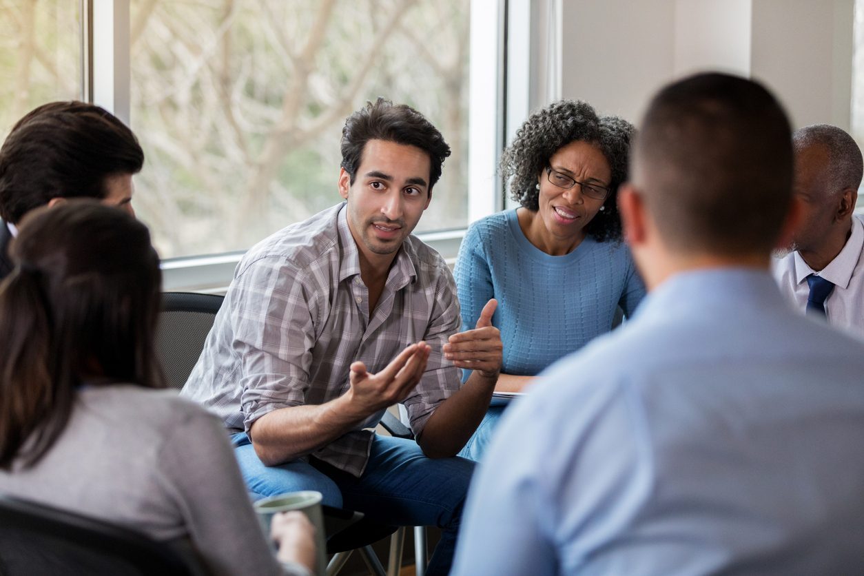 Group Discussion on Sobriety Tags and Alcohol Recovery Diverse group discussing sobriety tags in support group meeting