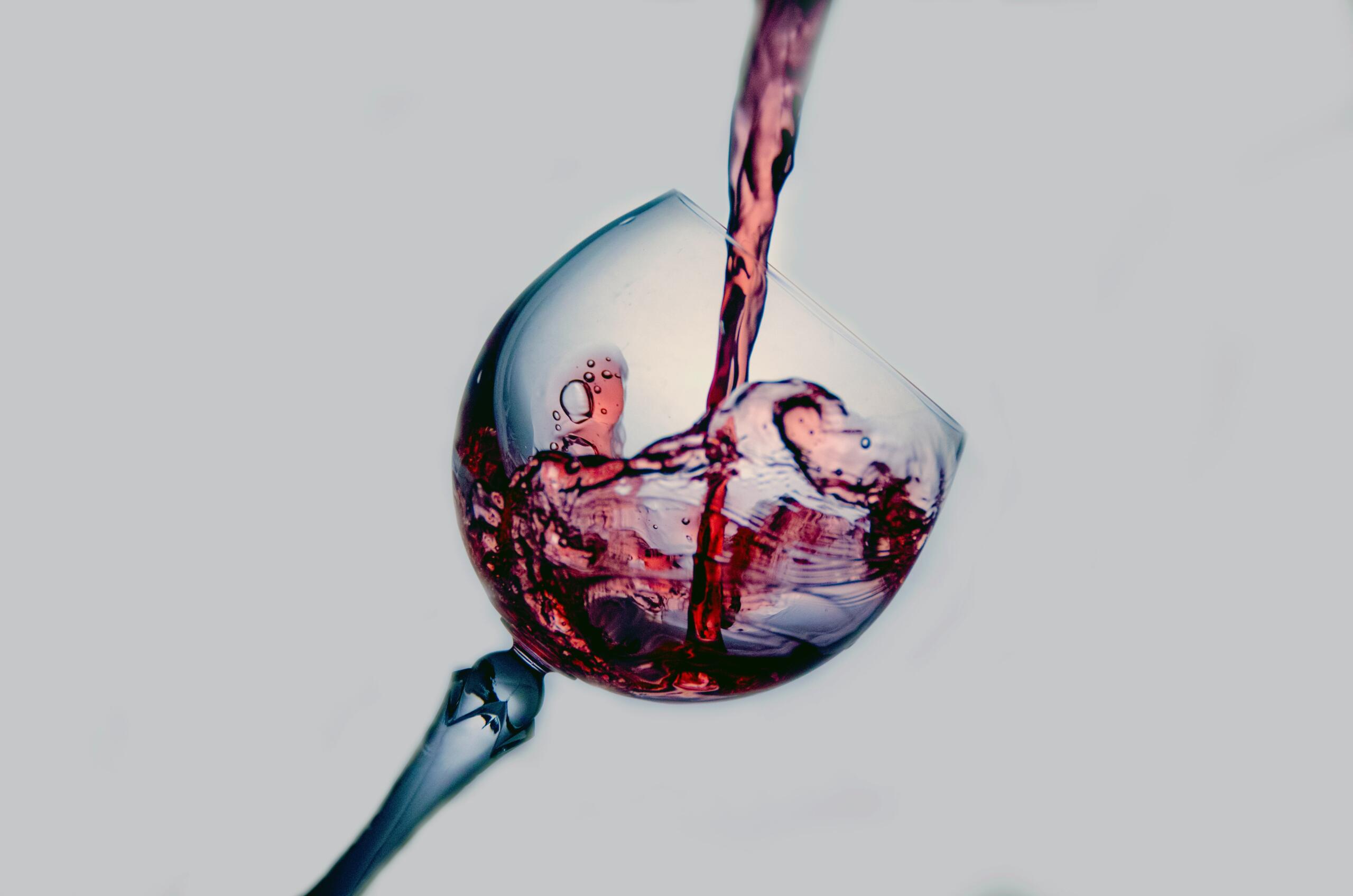 Close-up of red wine being poured, highlighting sugar in alcoholic drinks.