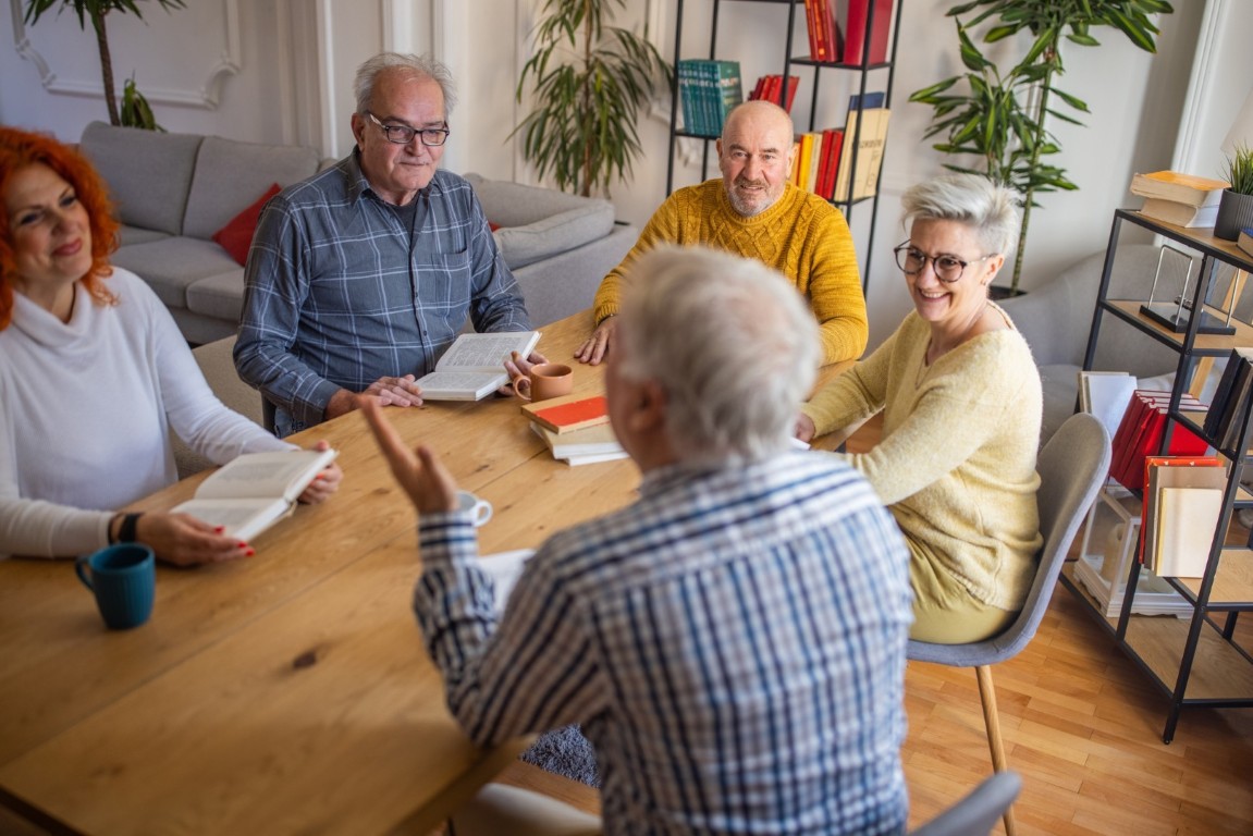 Support Groups Enhance Alcohol Recovery Journey Diverse group in a meeting discussing alcohol recovery with books