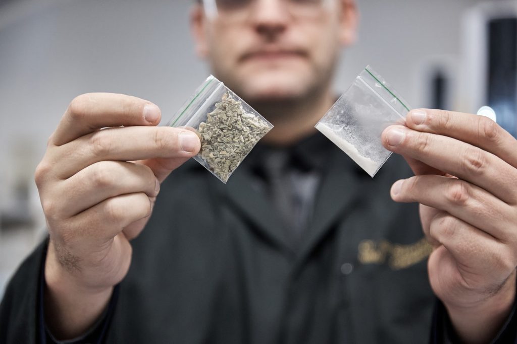Person holding small bags of alcohol and drugs